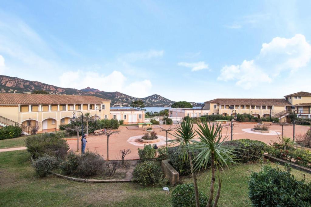 une cour dans une école avec des montagnes en arrière-plan dans l'établissement Résidence le Village de Cap Esterel - maeva Home - Appartement 2 Pièces 5 Personnes - Sélection MAE-3729, à Saint-Raphaël