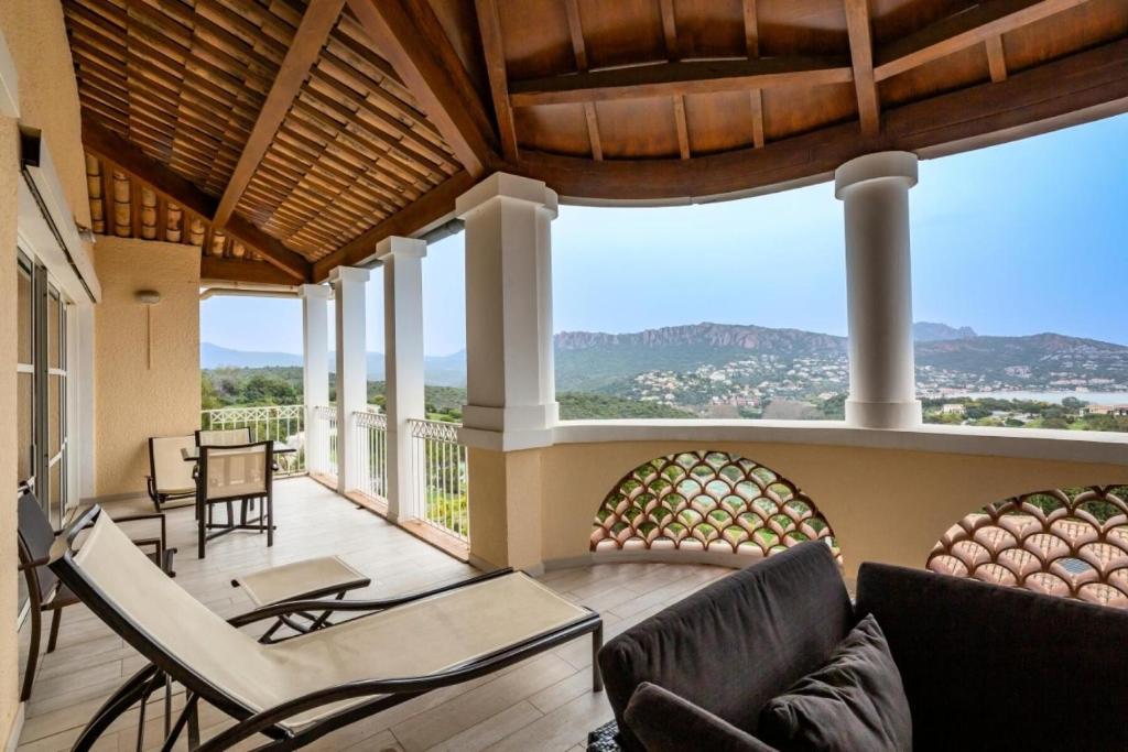 - un salon avec un canapé et des chaises sur une terrasse couverte dans l'établissement Résidence le Village de Cap Esterel - maeva Home - Appartement 4 pièces 8 personnes avec magnifique vue mer - Sélection - Super Home MAE-1481, à Saint-Raphaël