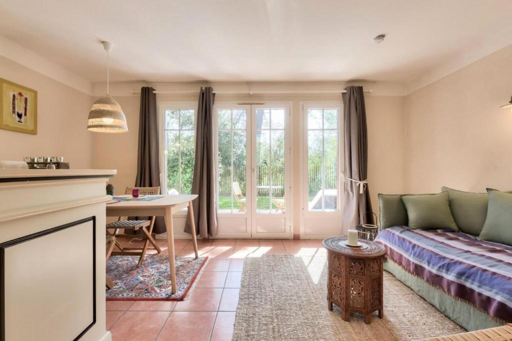 un salon avec un canapé et une table dans l'établissement Les Maisons de Lacanau les Pins - maeva Home - Maison 3 pièces 6 personnes - Sélection MAE-7964, à Lacanau