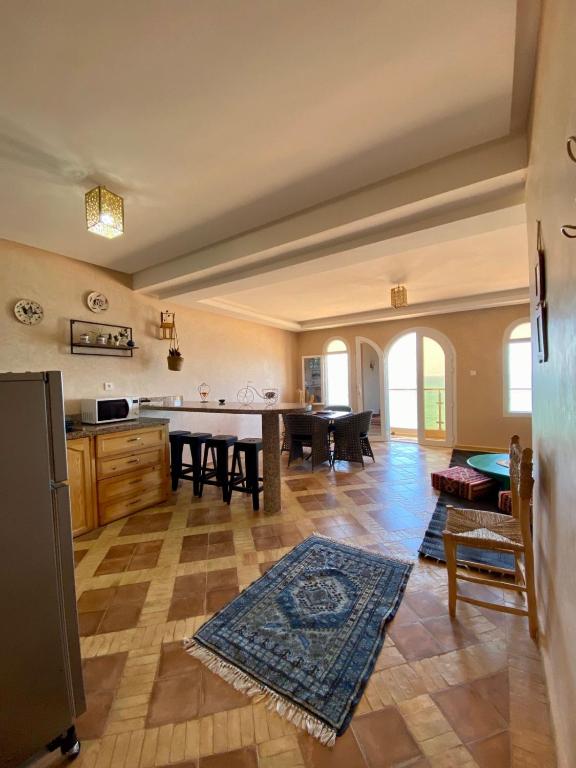 a large kitchen with a table and a dining room at Dar diafa samira in Mirleft