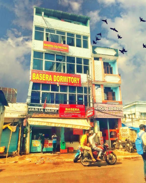 two people riding motorcycles in front of a building at BASERA DORMITORY in Lucknow