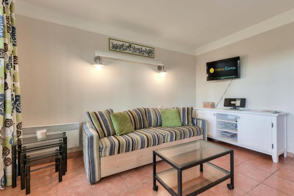 un salon avec un canapé et une table dans l'établissement Résidence Lacanau Les Pins - maeva Home - Maison 3 pièces 8 personnes - Confort MAE-4704, à Lacanau
