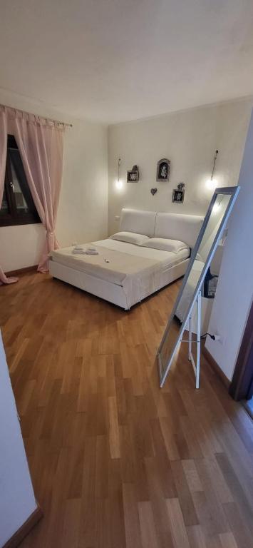 a large bedroom with a bed and a wooden floor at Mi Casita in Arzachena