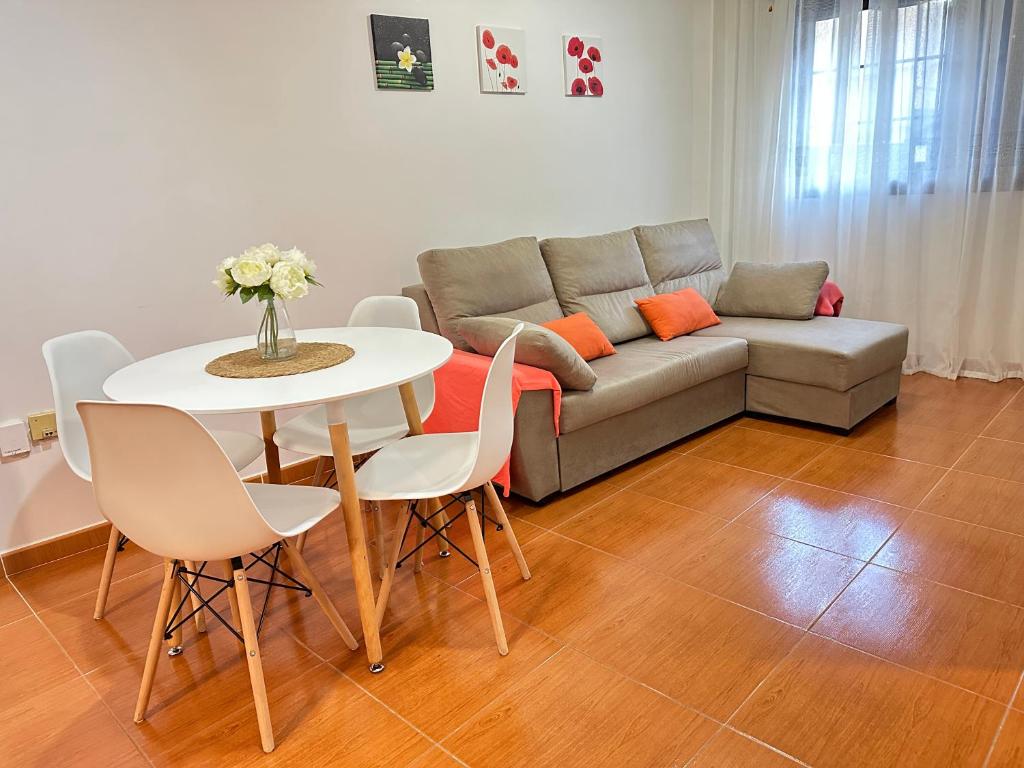sala de estar con sofá, mesa y sillas en Apartamento Salo, en Candelaria