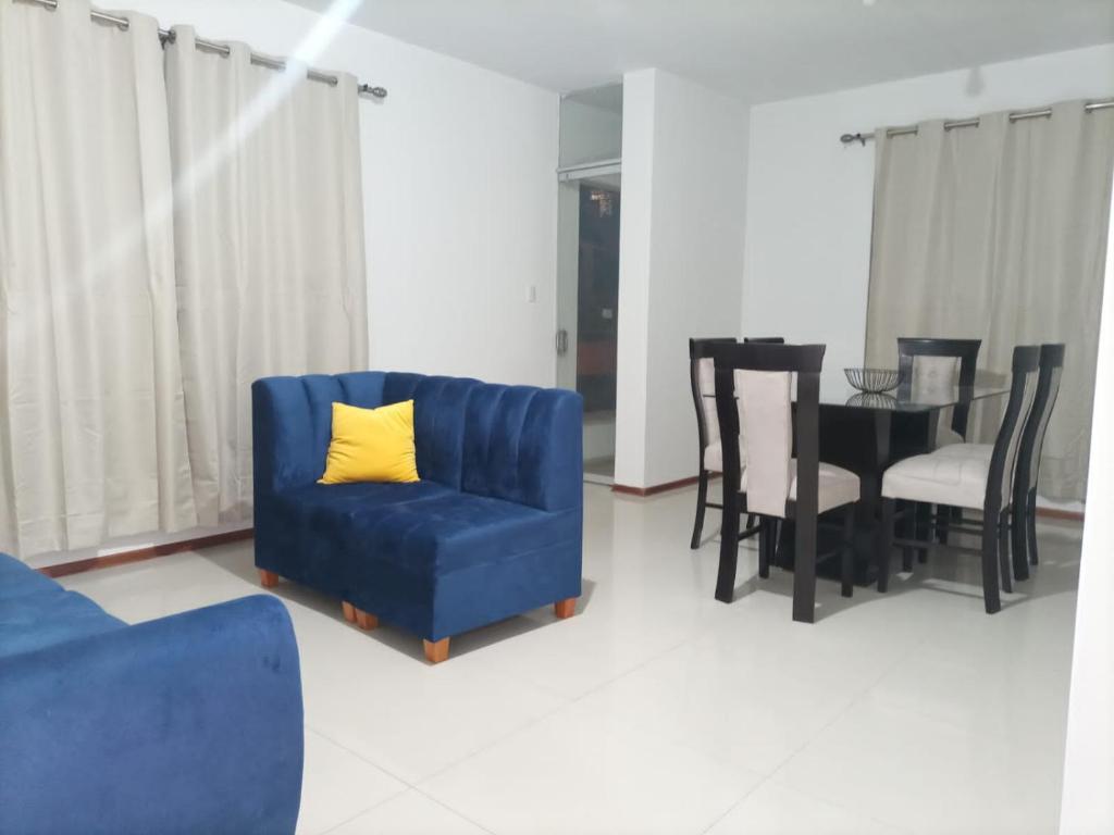een woonkamer met een blauwe stoel en een tafel bij Apartamento Meta Home zona exclusiva in Piura