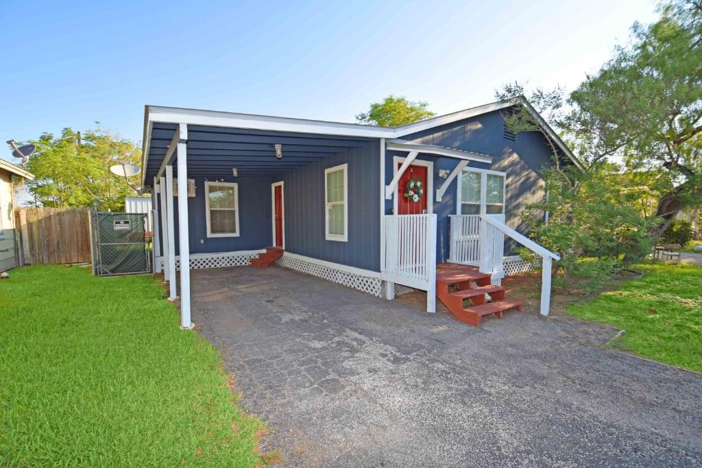 a blue tiny house with a porch and a yard at Home Sweet Home - Peace, Love, & Enjoy in Kingsville