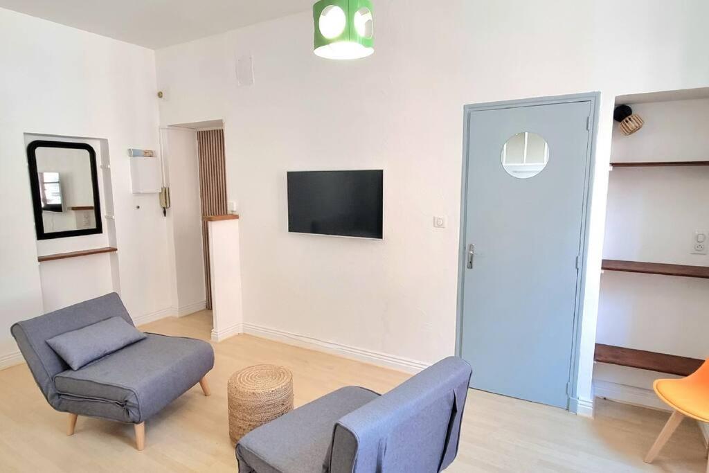 - un salon avec un canapé, une chaise et une télévision dans l'établissement Loft Vintage - Hypercentre - Metro - WIFI, à Toulouse