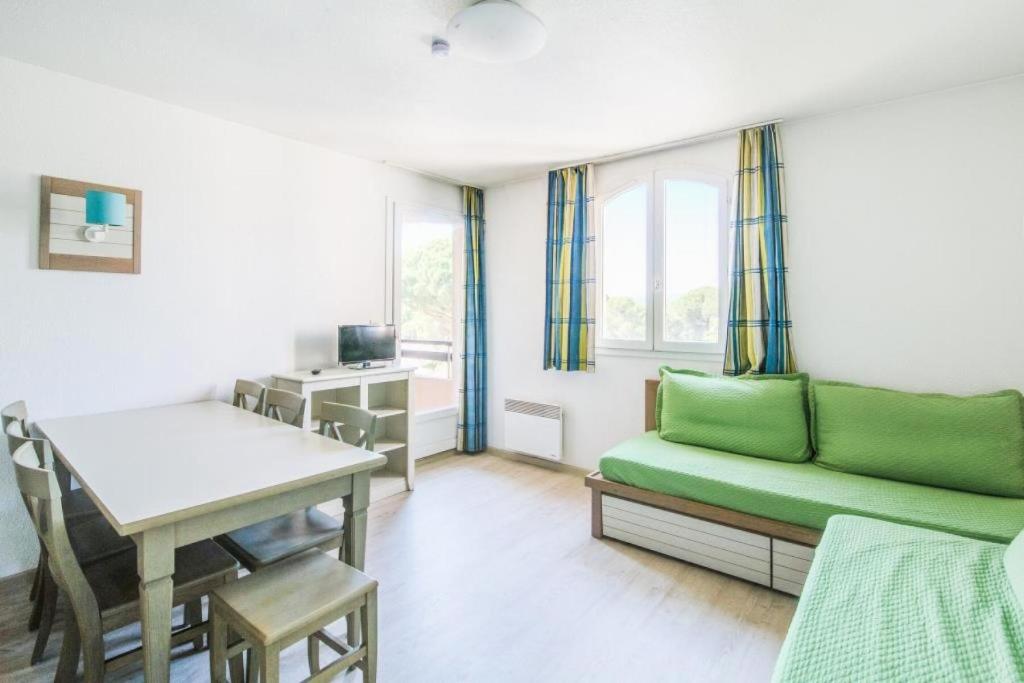 a living room with a green couch and a table at Résidence Saint-Raphaël Valescure - maeva Home - 2 Pièces 6 Personnes Sélection MAE-4876 in Valescure