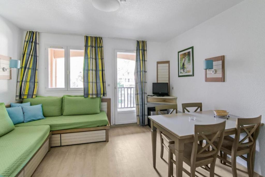 a living room with a green couch and a table at Résidence Saint-Raphaël Valescure - maeva Home - Studio 4 Personnes Sélection MAE-9504 in Valescure