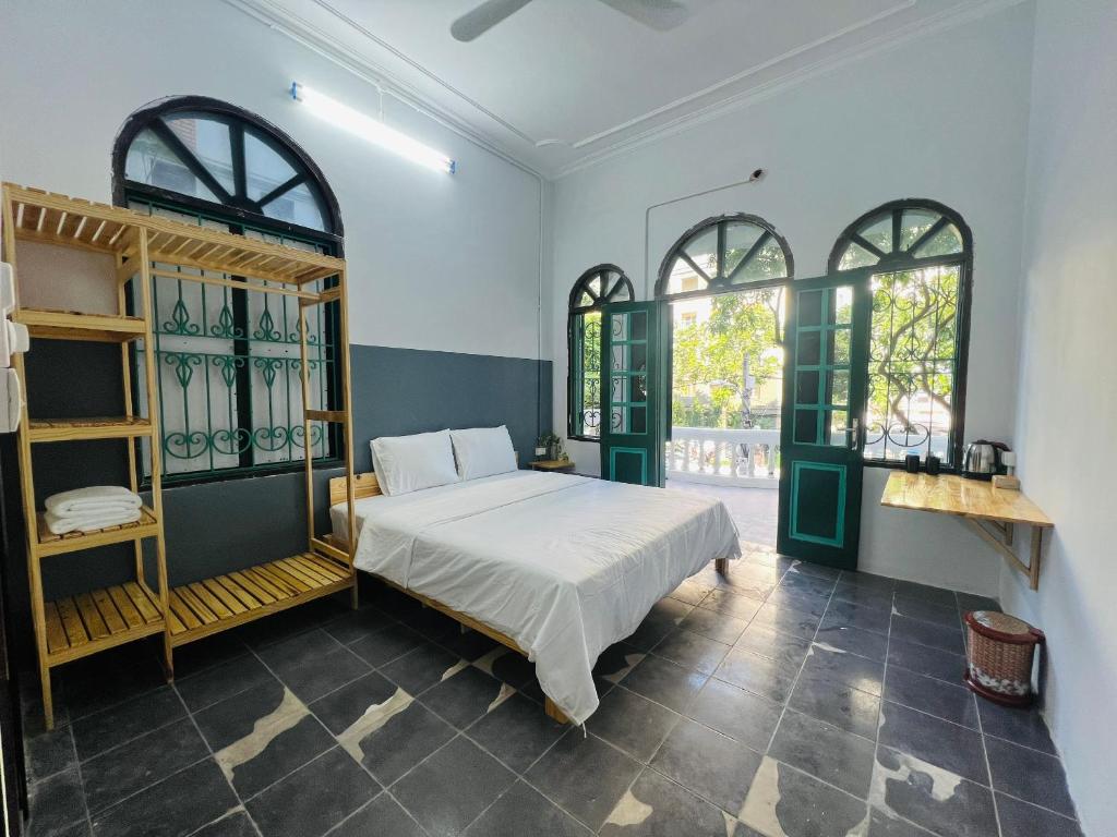 a bedroom with a bed and two windows at Hanoi AVANA HOMESTAY LONG BIEN in Hanoi
