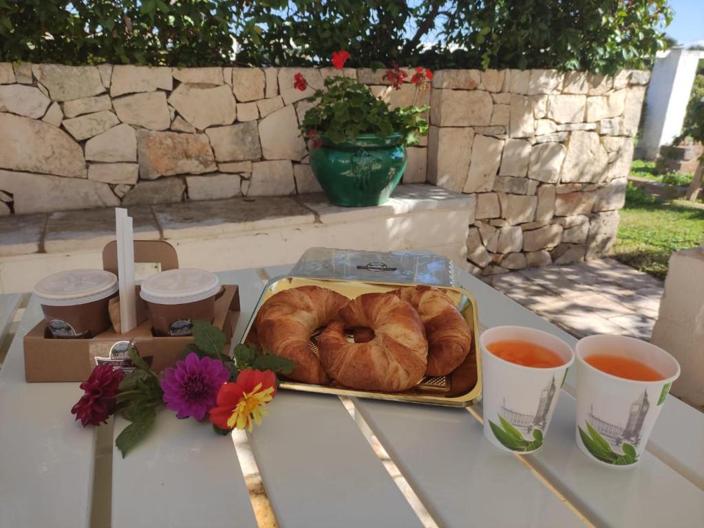 a tray of croissants and two cups of tea on a table at Trullo Fanizza in Alberobello