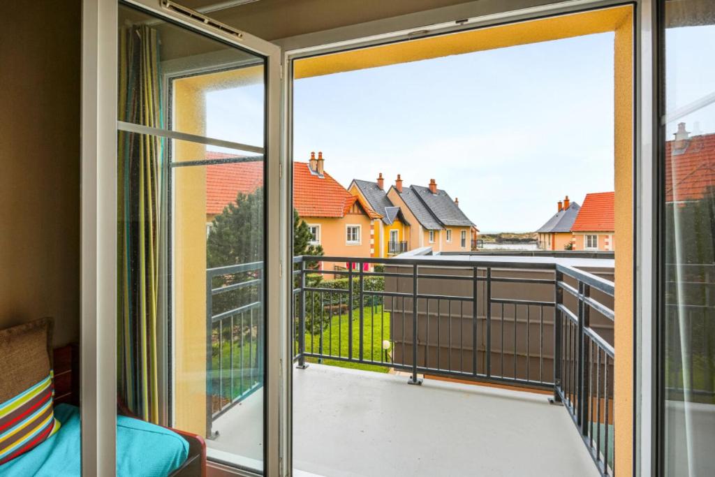 a room with a balcony with sliding glass doors at Résidence Port Guillaume - maeva Home - Appartement 2 pièces 6 pers Sélection MAE-7351 in Dives-sur-Mer