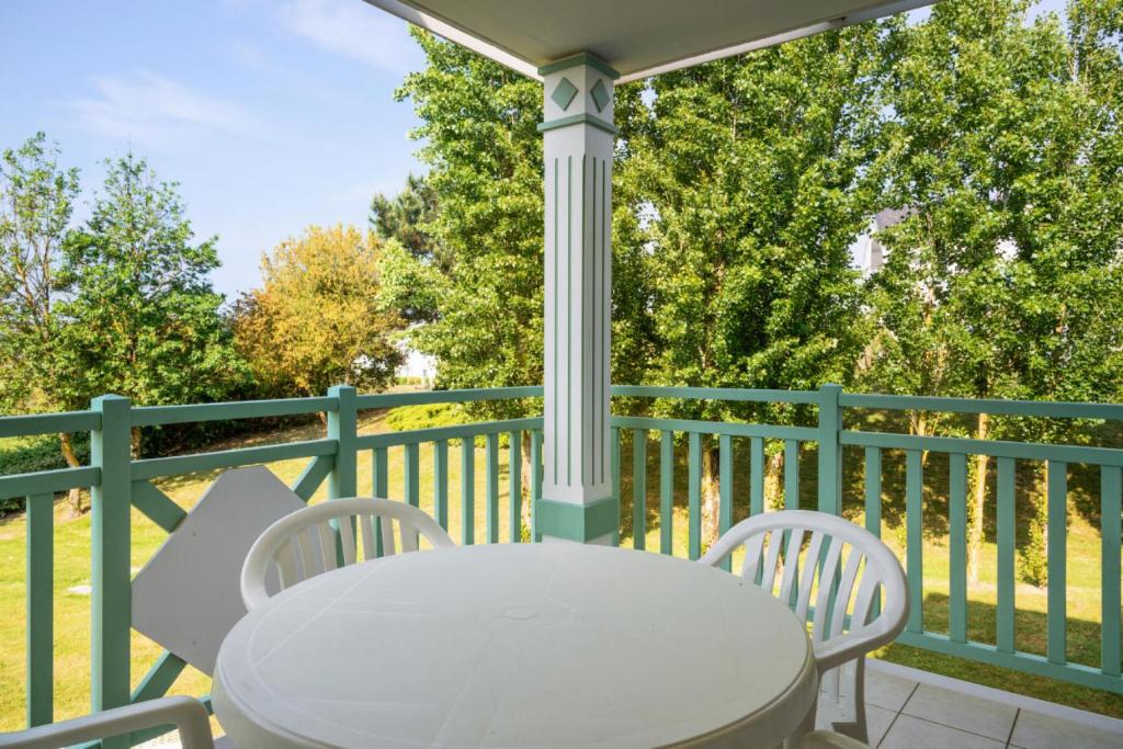 - une table blanche et 2 chaises sur une terrasse couverte dans l'établissement Résidence Port Bourgenay - maeva Home - 2 Pièces 4 Personnes Selection MAE-2072, à Talmont-Saint-Hilaire