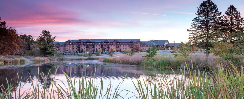 a hotel with a pond in front of a building at Wyndham Glacier Canyon 2 BR in Baraboo