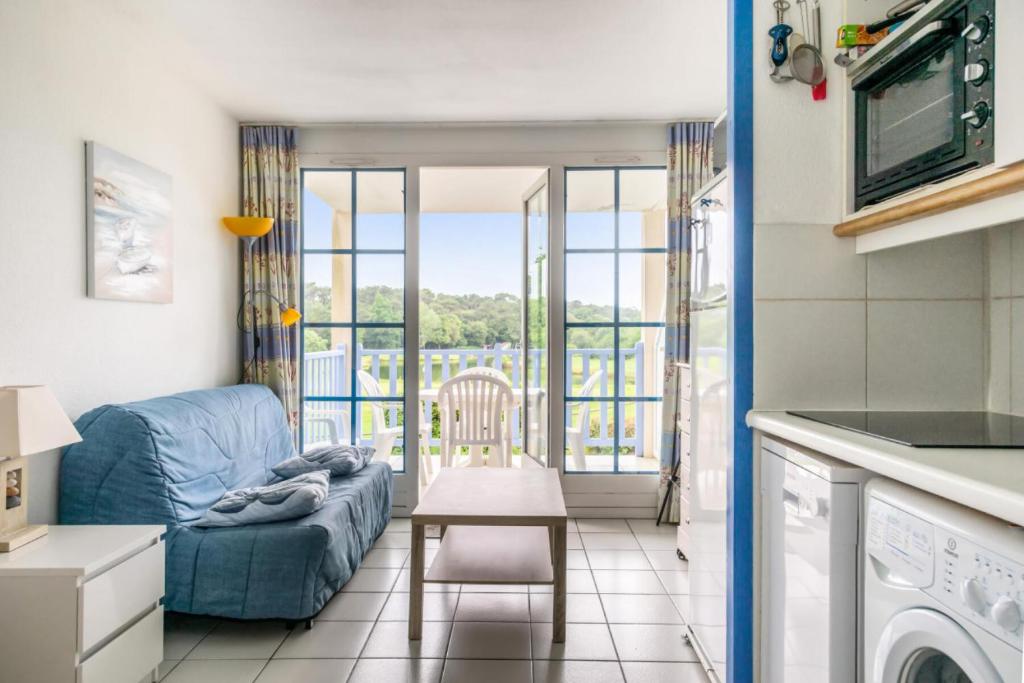 un salon avec un canapé bleu et une table dans l'établissement Résidence Port Bourgenay - maeva Home - Appartement 2 pièces 4 personnes Confort MAE-2708, à Talmont-Saint-Hilaire