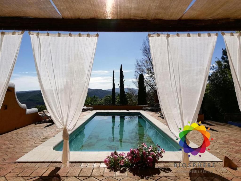 a swimming pool with white drapes and a pool at Quinta do Barrieiro - Art Selection by Maria Leal da Costa in Marvão