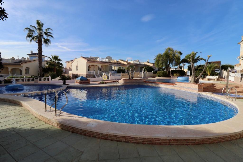a large swimming pool in a yard with houses at Casa la Pajarera in Ciudad Quesada
