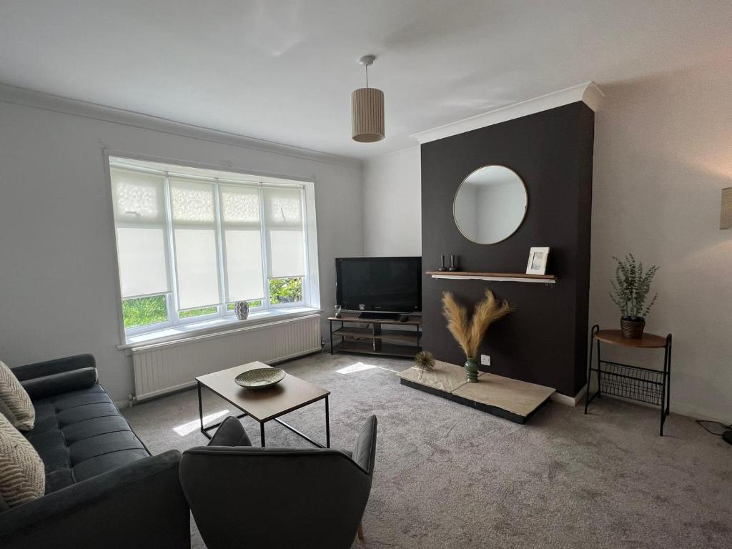 sala de estar con sofá y espejo en Alexander Apartments Marsden en South Shields