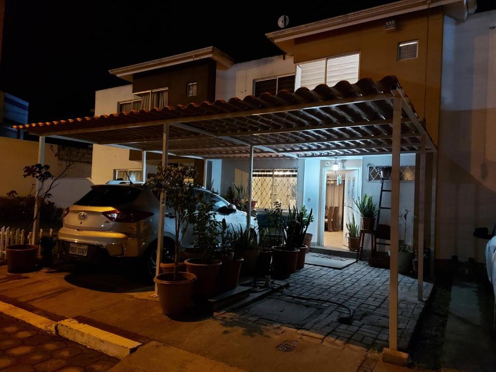 a car parked under a pergola in front of a house at Orange Blossom in Riobamba