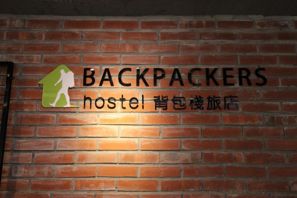 a sign on a brick wall that reads backpackers hostel at Backpackers Hostel - Ximen in Taipei
