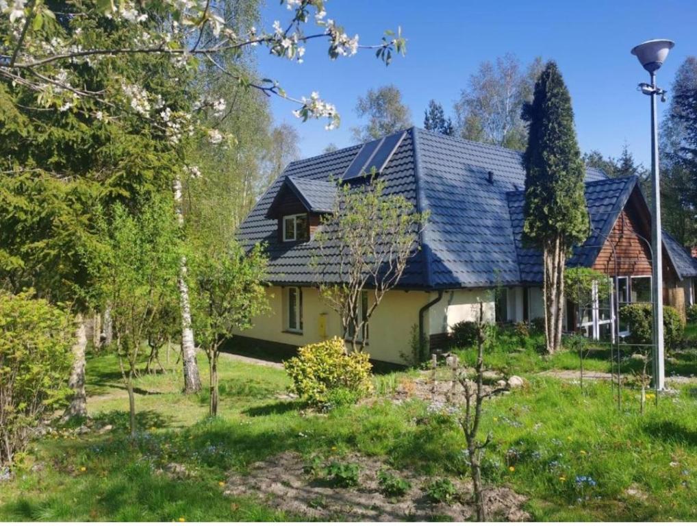 uma casa com um telhado azul num quintal em Ranczo u Andrzeja em Rybaki