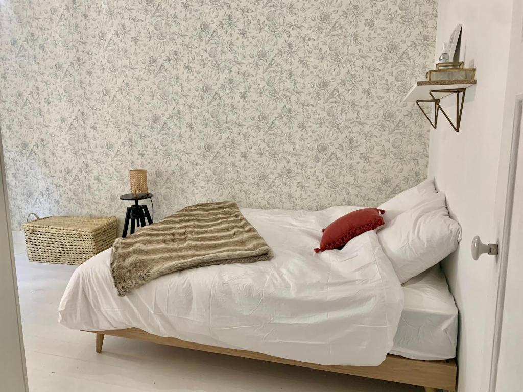 1 dormitorio con cama blanca y almohada roja en Chez Tess, en Metz