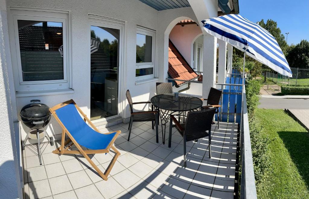 a patio with a table and chairs and an umbrella at Ferienwohnung in Buchen - Pure Entspannung im Odenwald in Buchen