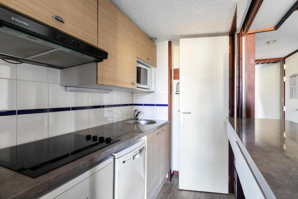 une cuisine avec un évier et une cuisinière dans l'établissement Résidence Port du Crouesty - maeva Home - Appartement 2 pièces 5 personnes Confort MAE-4782, à Arzon