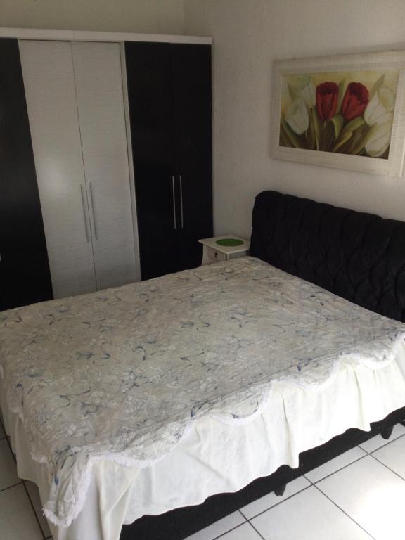 een slaapkamer met een groot bed met een zwart hoofdeinde bij Pousada Boulevard in Florianópolis