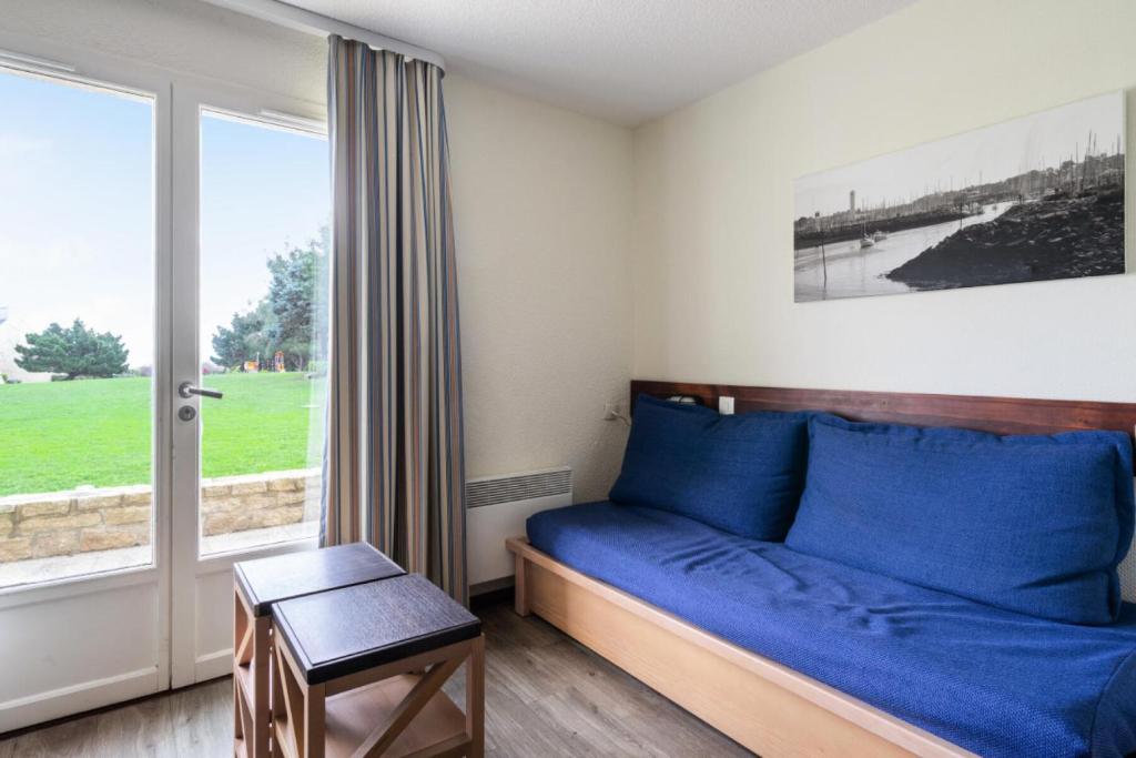 une chambre avec un lit bleu et une fenêtre dans l'établissement Résidence Port du Crouesty - maeva Home - Appartement 2 pièces 5 personnes Confort MAE-4763, à Arzon