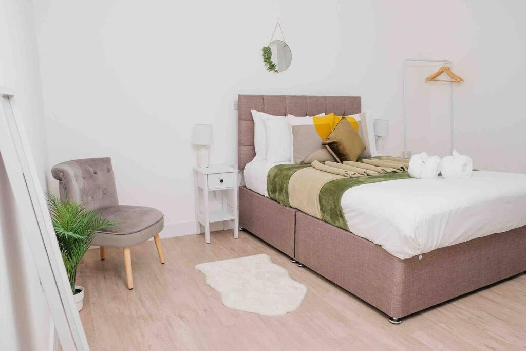 um quarto com uma cama grande e uma cadeira em Garden of Eden 1 Bedroom Flat in Fishponds em Bristol