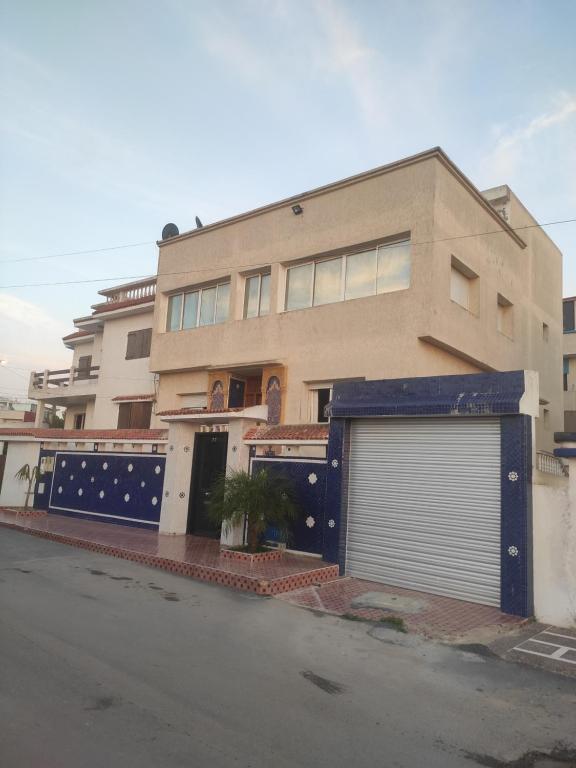 duży budynek z garażem przed nim w obiekcie Family House w mieście Kenitra