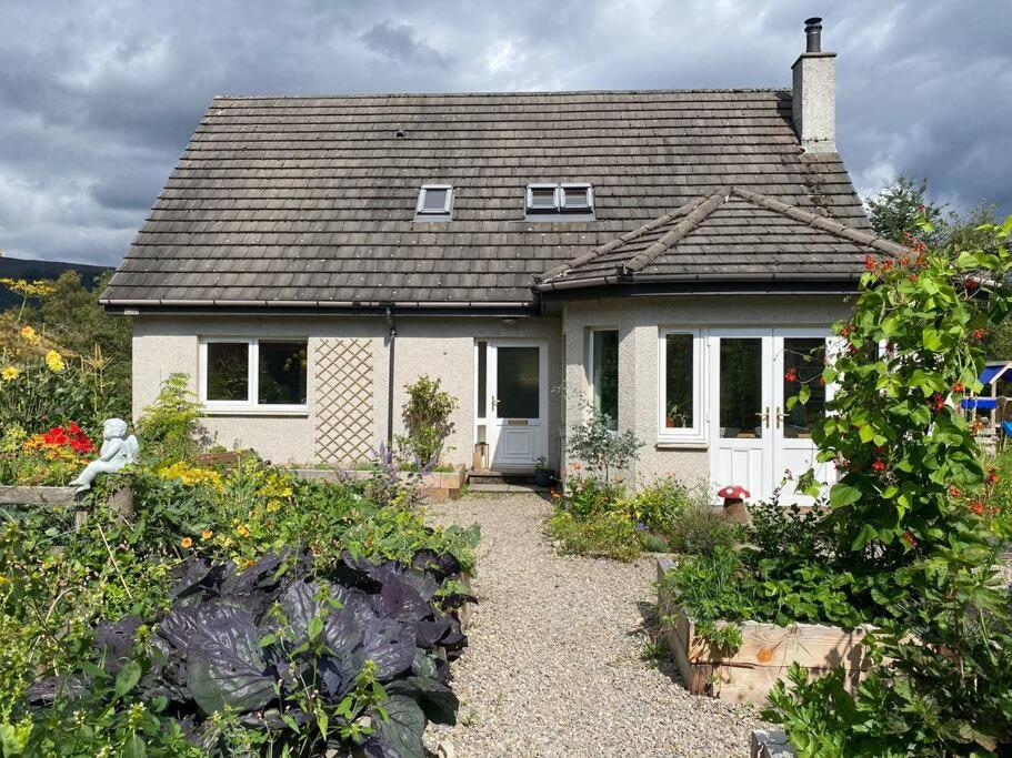 a small white house with a garden in front of it at Homestead House, Fort Augustus in Fort Augustus