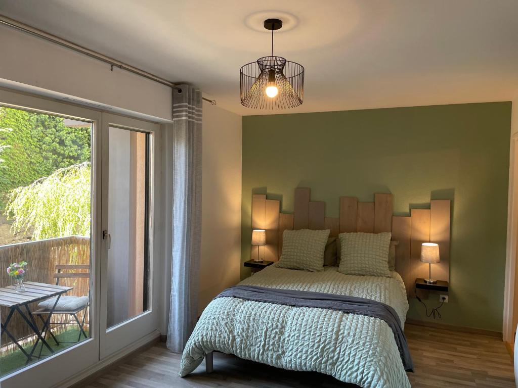 een slaapkamer met een bed met een groene muur bij Studio Ma Préférence in Horbourg