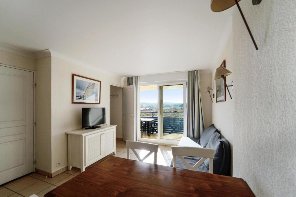 a living room with a television and a desk with a window at Résidence Bleu Marine - maeva Home - Appartement 2 pièces 4 personnes Confort MAE-2510 in Lacanau