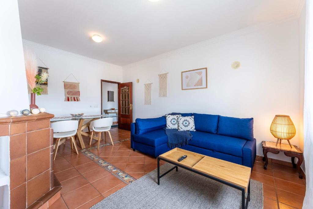 a living room with a blue couch and a table at Peaceful 1 BDR Apartment W/ Balcony by LovelyStay in Almancil