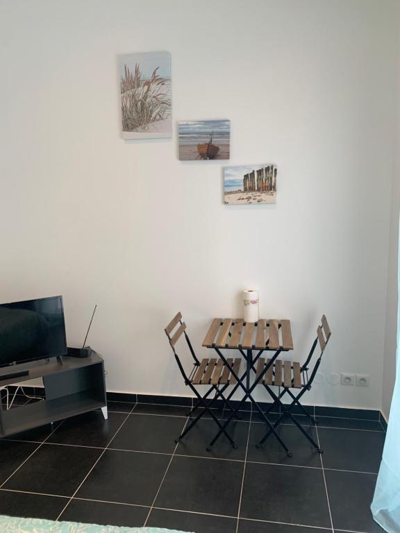 - un salon avec une table et des chaises dans l'établissement Jolie maisonnette Nancy centre, à Nancy