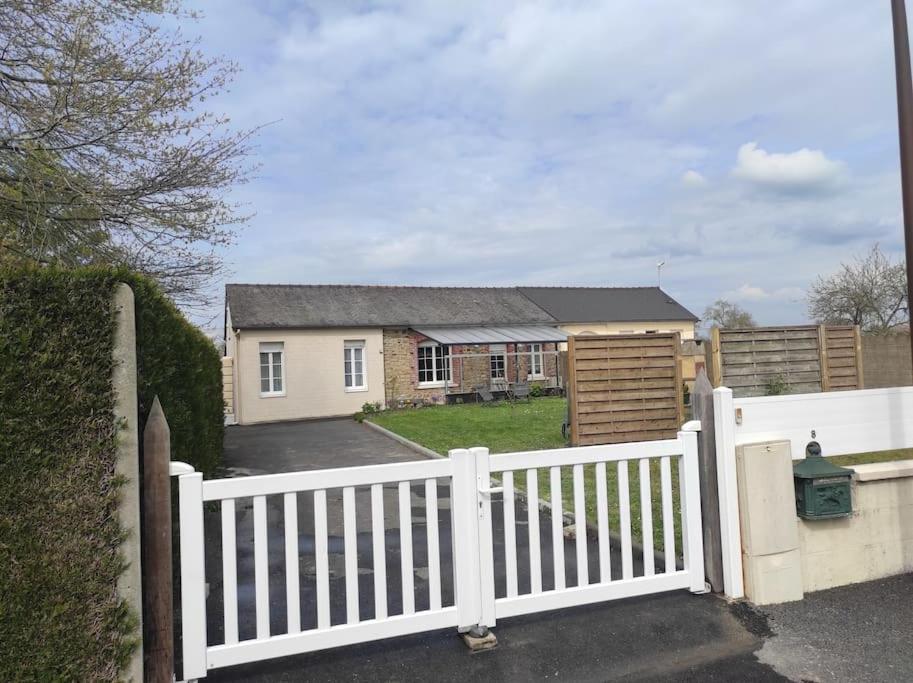 une clôture blanche devant une maison dans l'établissement Maison proche du Mont Saint Michel (10mn) 4/5 pers, à Pontorson