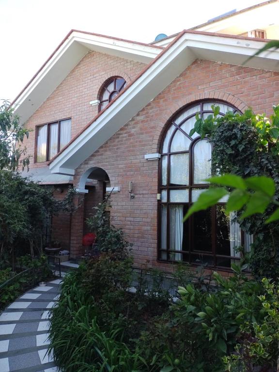 a brick house with a walkway in front of it at House garden airport in Zamacola