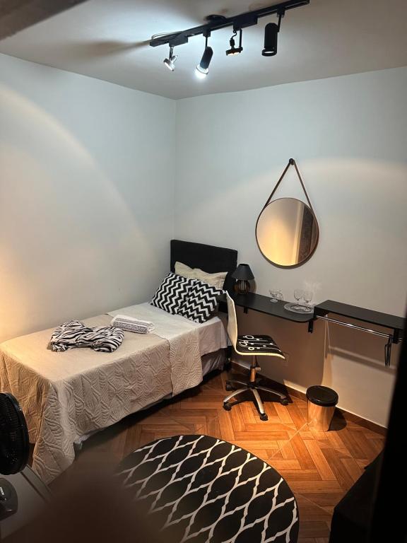 um quarto com uma cama, uma secretária e uma cadeira em Quarto duplo em Belo Horizonte