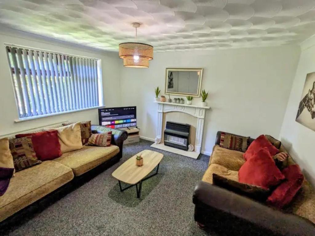 a living room with two couches and a fireplace at K Suites - Harrogate Terrace in Bradford