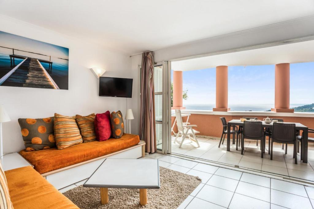 un salon avec un canapé et une salle à manger dans l'établissement Résidence le Village de Cap Esterel - maeva Home - Appartement 3 pièces 7 personnes - Confort MAE-0548, à Saint-Raphaël