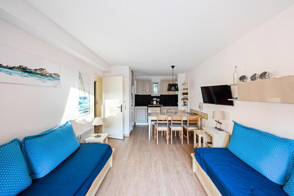 un salon avec un canapé bleu et une table dans l'établissement Résidence La Pinède - maeva Home - Appartement 2 pièces 6 personnes Sélection - WIFI inclus MAE-4732, à Hyères