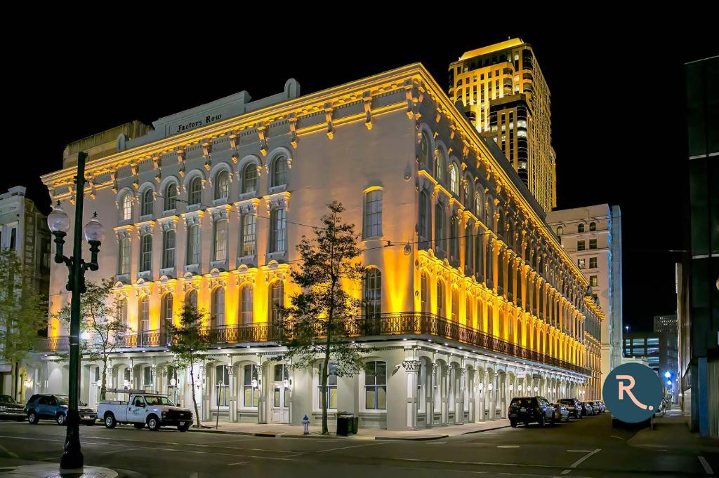 a lit up building on a city street at night at Roami at Factors Row in New Orleans