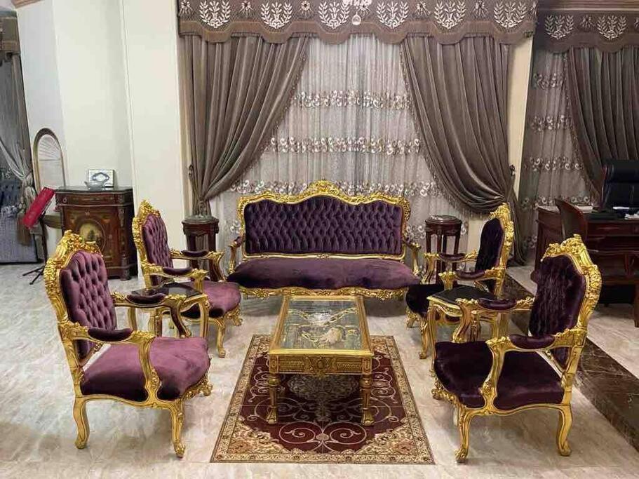 a living room with a couch and chairs and a table at Bright And Vintage 3 BR Suite in Cairo