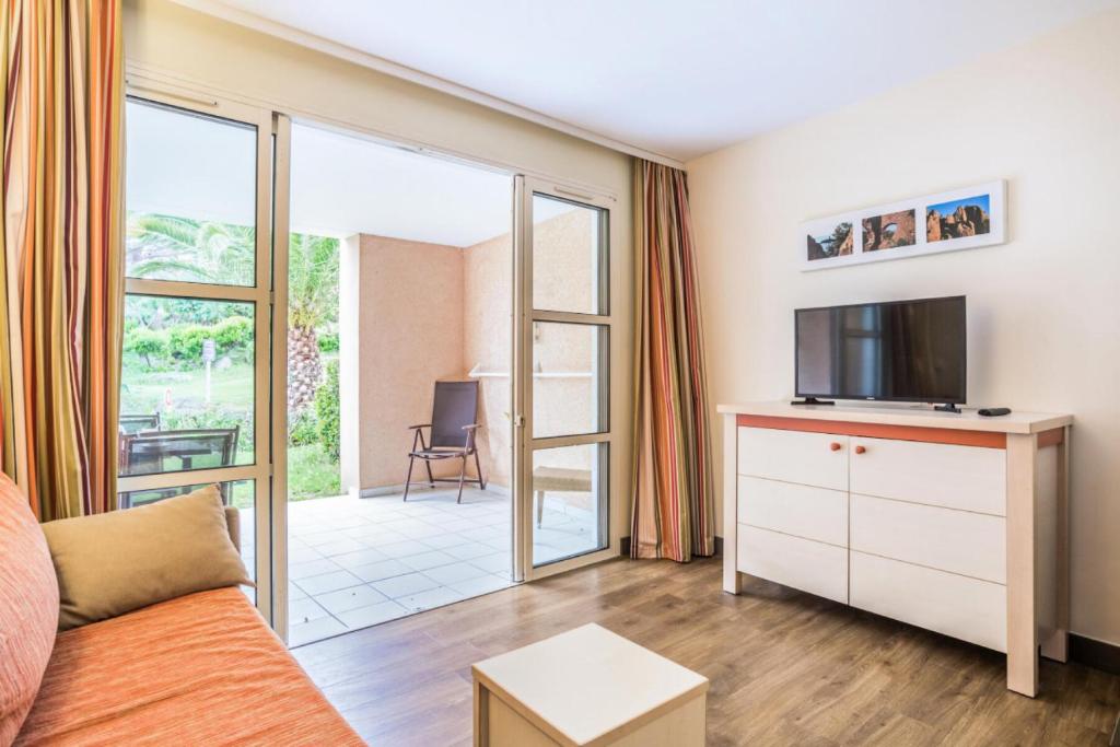 un salon avec un canapé et une télévision dans l'établissement Résidence le Village de Cap Esterel - maeva Home - Studio 4 personnes - Sélection MAE-4173, à Saint-Raphaël