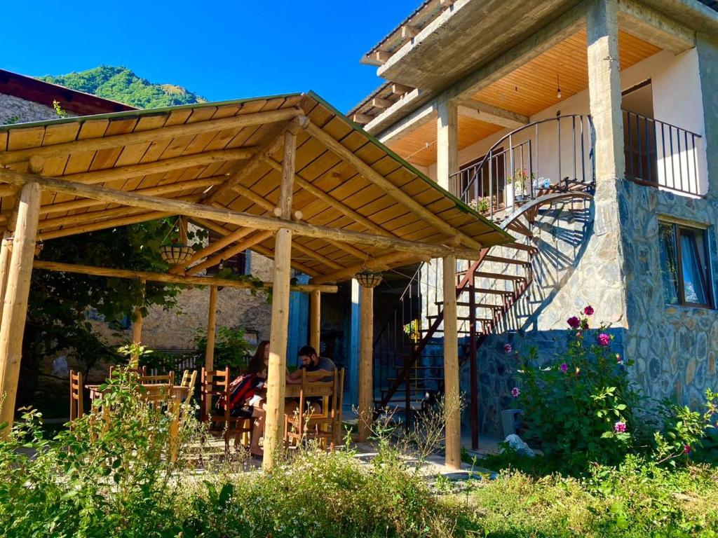a wooden pergola on the side of a house at Guesthouse Venera in Mestia