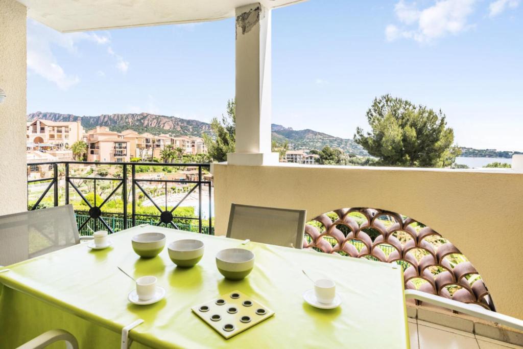 d'une table et de chaises avec vue sur un balcon. dans l'établissement Résidence le Village de Cap Esterel - maeva Home - Appartement 2 pièces 5 personnes - Sélection MAE-7252, à Saint-Raphaël