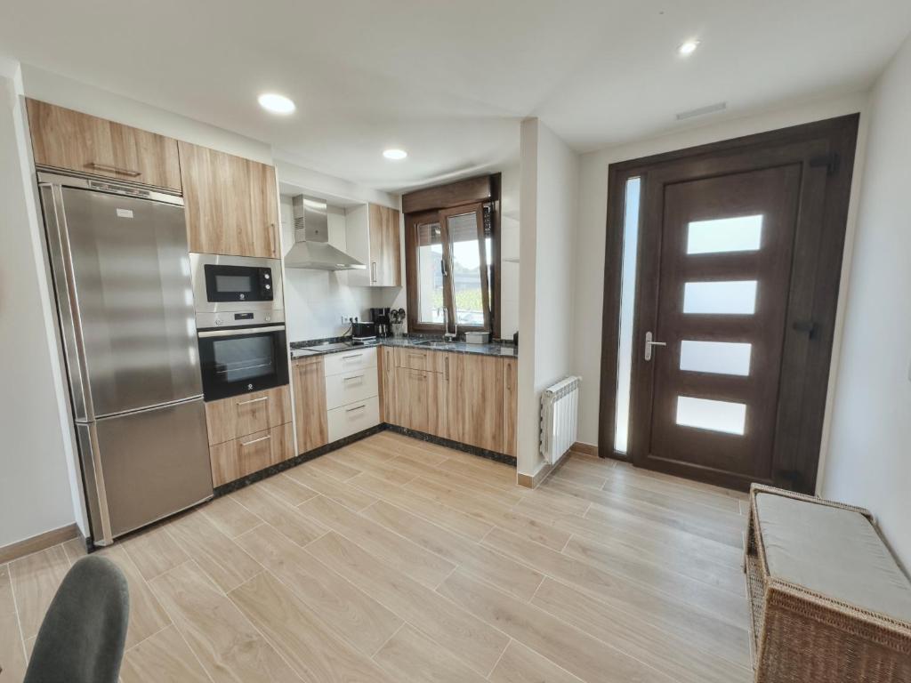 una cocina con electrodomésticos de acero inoxidable y armarios de madera en Apartamento Albar, en Poio