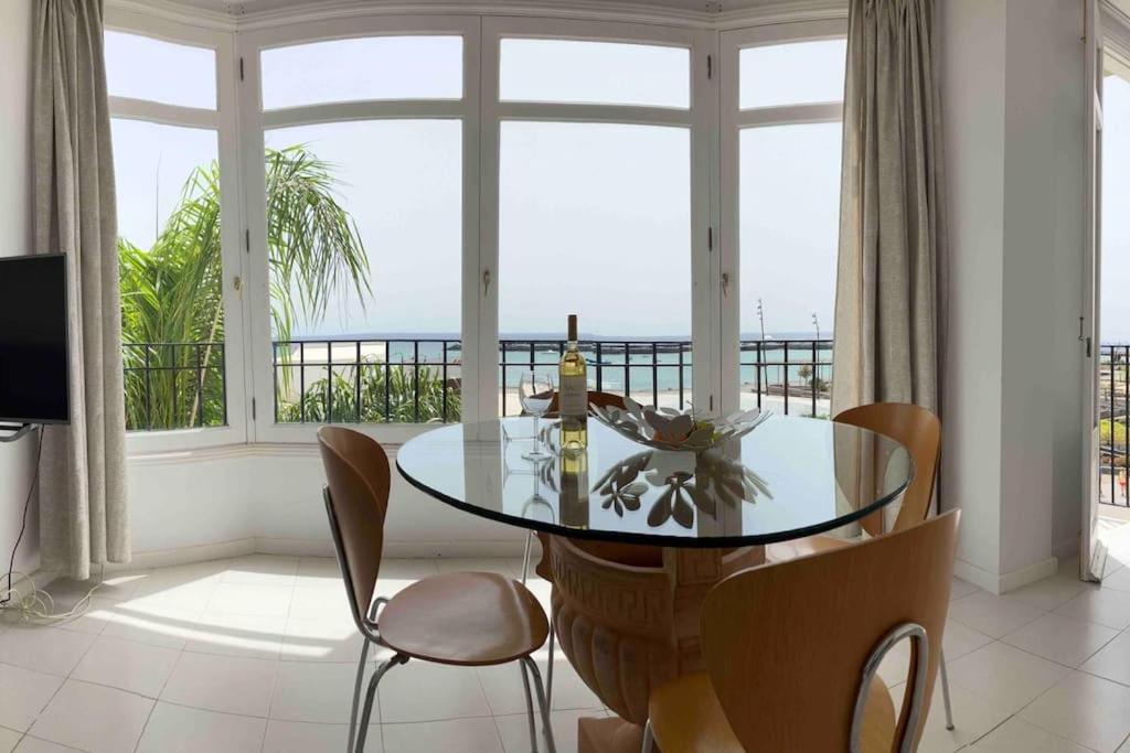 una sala da pranzo con tavolo, sedie e finestra di Sea&Harbour Arrecife ad Arrecife